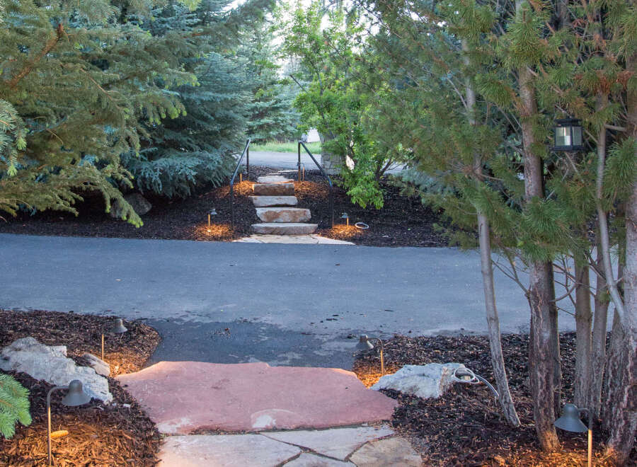 Discover the charm of this beautifully landscaped property, featuring a flagstone pathway that leads to a welcoming entrance.