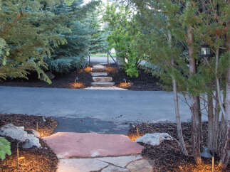 Discover the charm of this beautifully landscaped property, featuring a flagstone pathway that leads to a welcoming entrance.