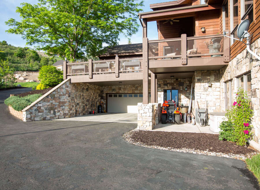 This stunning property boasts a beautiful stone exterior and a charming covered deck, perfect for enjoying the outdoors.