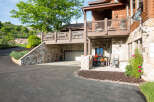 This stunning property boasts a beautiful stone exterior and a charming covered deck, perfect for enjoying the outdoors.