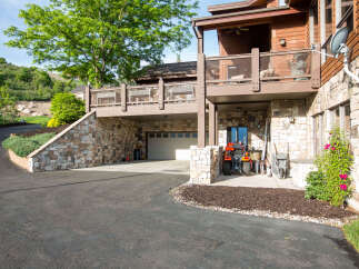 This stunning property boasts a beautiful stone exterior and a charming covered deck, perfect for enjoying the outdoors.