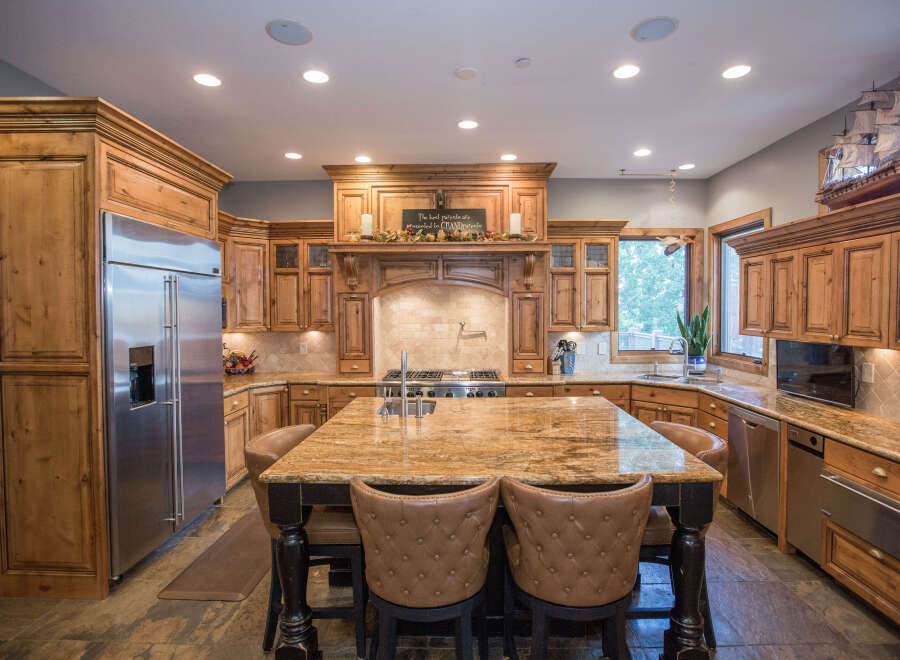 Step into this stunning kitchen, featuring custom wooden cabinetry and a spacious island with seating.