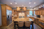 Step into this stunning kitchen, featuring custom wooden cabinetry and a spacious island with seating.