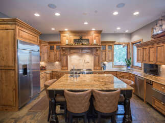 Step into this stunning kitchen, featuring custom wooden cabinetry and a spacious island with seating.
