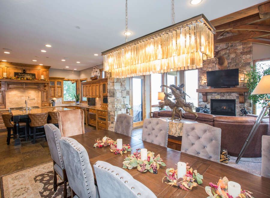 This luxurious dining room features a stunning chandelier and a large wooden dining table, perfect for hosting gatherings.