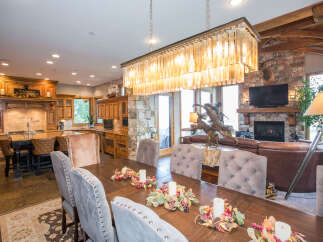 This luxurious dining room features a stunning chandelier and a large wooden dining table, perfect for hosting gatherings.