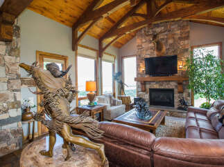 Step into luxury with this stunning living space, featuring a cozy fireplace and a beautiful stone accent wall.
