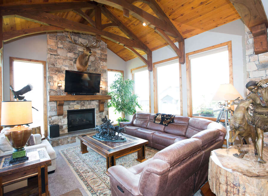 Step into luxury with this stunning living room, featuring a cozy fireplace and a majestic elk mount.