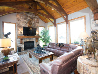 Step into luxury with this stunning living room, featuring a cozy fireplace and a majestic elk mount.