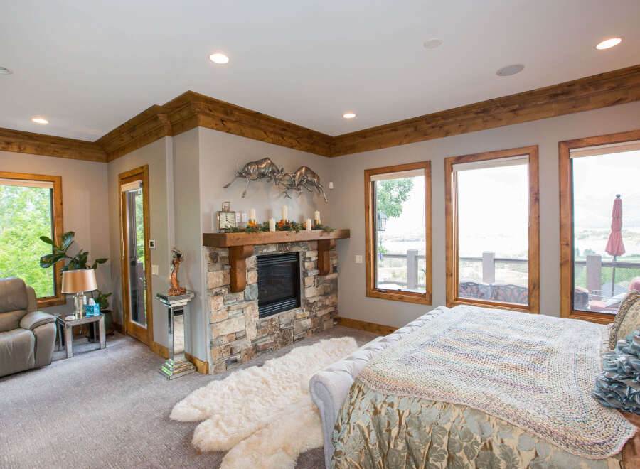 This luxurious bedroom boasts a cozy fireplace and a plush rug, creating a warm and inviting atmosphere.