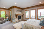 This luxurious bedroom boasts a cozy fireplace and a plush rug, creating a warm and inviting atmosphere.