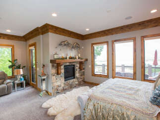 This luxurious bedroom boasts a cozy fireplace and a plush rug, creating a warm and inviting atmosphere.