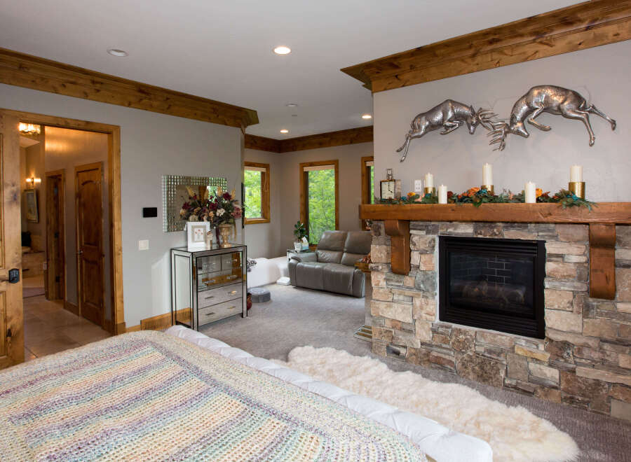 Discover luxury living in this stunning bedroom, featuring a cozy fireplace and elegant decor.