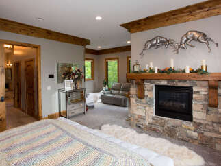 Discover luxury living in this stunning bedroom, featuring a cozy fireplace and elegant decor.