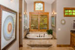 This luxurious bathroom features a stunning soaking tub surrounded by elegant tile work and a marble countertop.