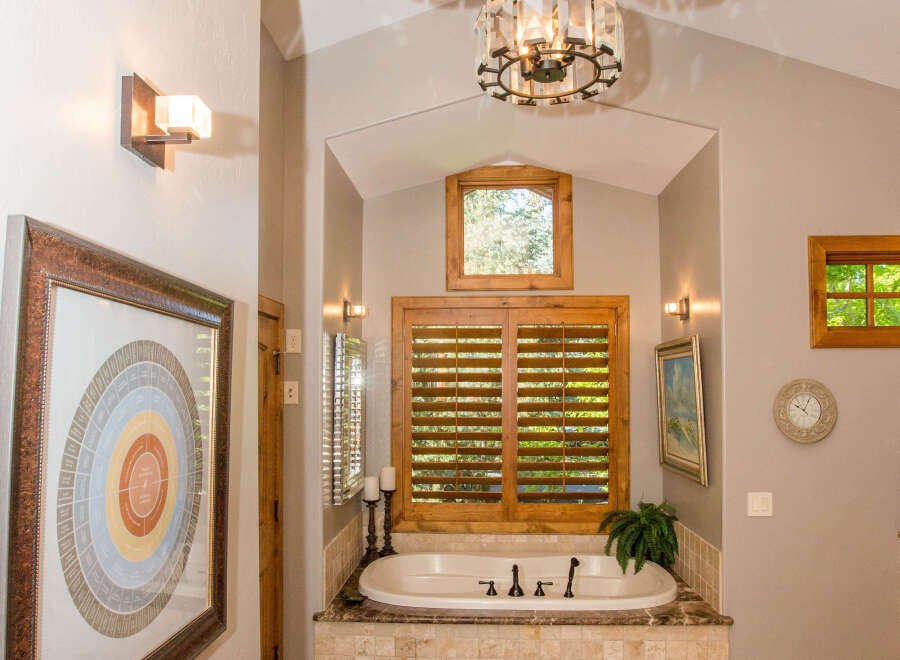 This luxurious bathroom features a stunning design with elegant chandeliers and a relaxing bathtub.