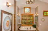 This luxurious bathroom features a stunning design with elegant chandeliers and a relaxing bathtub.