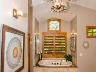 This luxurious bathroom features a stunning design with elegant chandeliers and a relaxing bathtub.