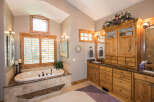 Step into luxury with this stunning bathroom featuring a beautiful soaking tub and elegant cabinetry.