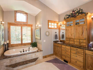 Step into luxury with this stunning bathroom featuring a beautiful soaking tub and elegant cabinetry.