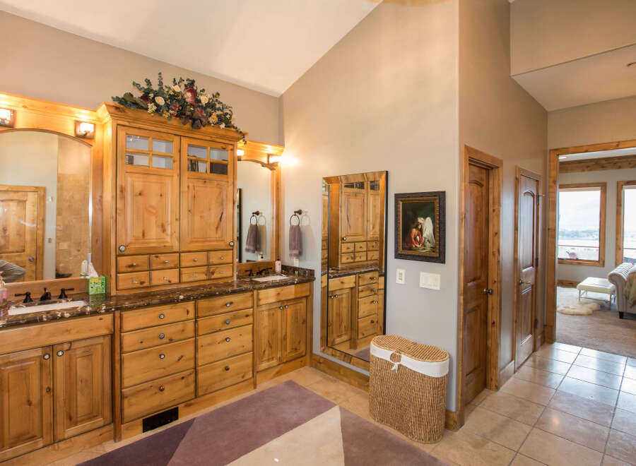 This luxurious bathroom boasts custom wooden cabinetry, offering ample storage and a touch of rustic elegance.