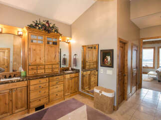 This luxurious bathroom boasts custom wooden cabinetry, offering ample storage and a touch of rustic elegance.