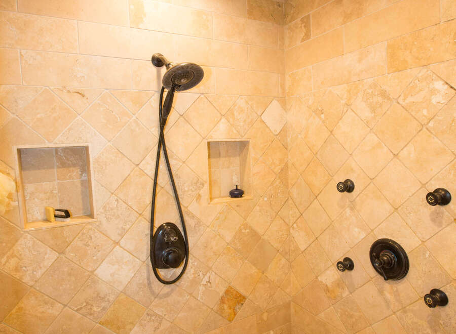 Step into luxury with this stunning bathroom featuring a custom tiled shower.
