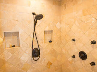 Step into luxury with this stunning bathroom featuring a custom tiled shower.