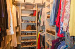 Step into this well-organized walk-in closet, offering ample storage for your wardrobe.