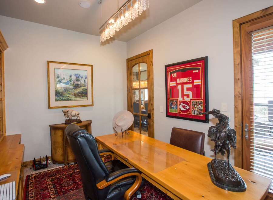 Step into this inviting home office, featuring a stylish desk and comfortable seating.