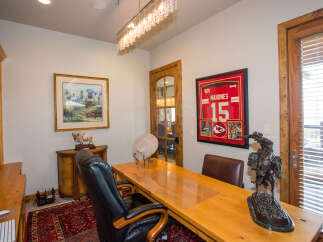 Step into this inviting home office, featuring a stylish desk and comfortable seating.