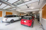 This spacious garage boasts ample room for multiple vehicles, including a sleek white SUV and a vibrant red Mini Cooper.