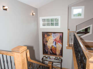 This stunning property features a grand staircase with elegant wooden accents and wrought iron railings.