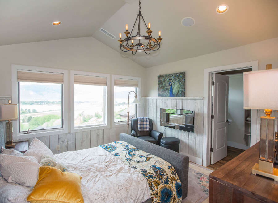 This stunning bedroom boasts a luxurious ambiance with its elegant chandelier and cozy seating area.