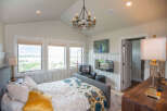 This stunning bedroom boasts a luxurious ambiance with its elegant chandelier and cozy seating area.