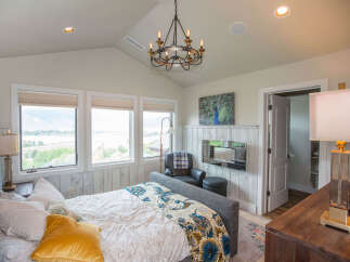 This stunning bedroom boasts a luxurious ambiance with its elegant chandelier and cozy seating area.