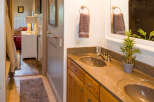This beautiful bathroom features a double vanity with a stunning granite countertop and wooden cabinets.