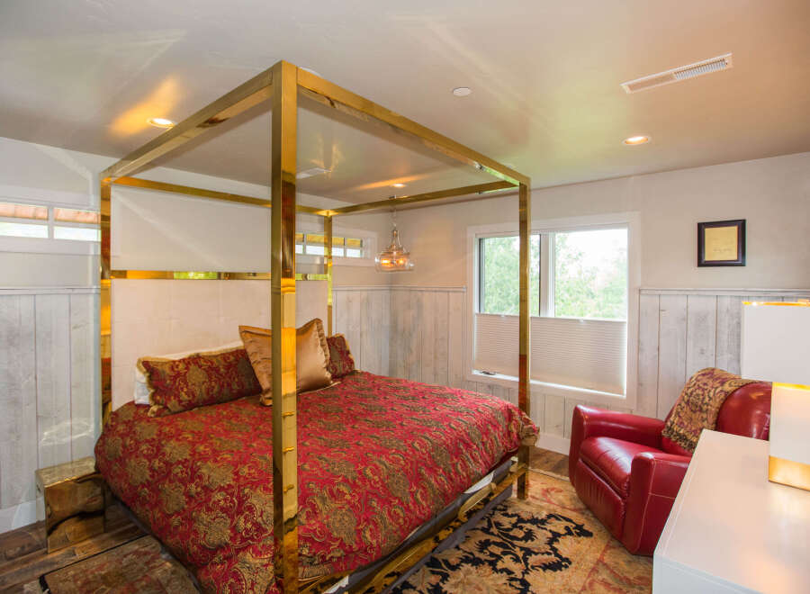 This luxurious bedroom features a stunning gold canopy bed, creating a focal point of elegance.