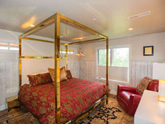 This luxurious bedroom features a stunning gold canopy bed, creating a focal point of elegance.