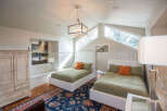 This charming bedroom features two cozy beds with plush bedding and vibrant orange accent pillows.