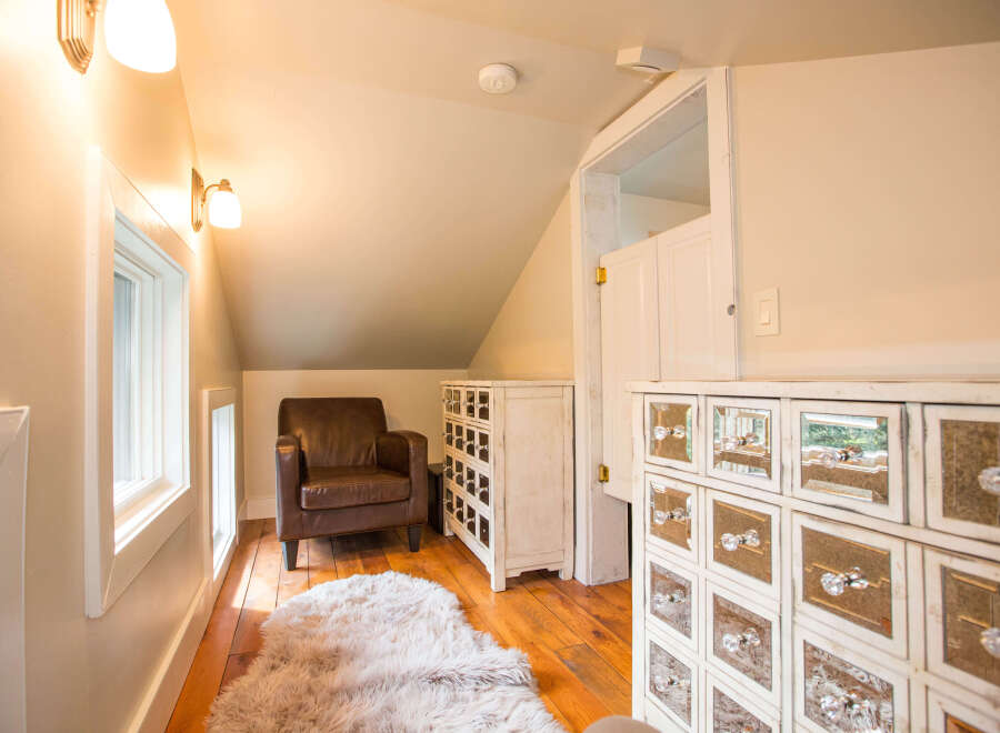 This charming room features a cozy leather armchair and a plush rug, creating a warm and inviting atmosphere.