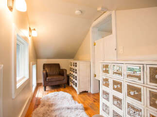 This charming room features a cozy leather armchair and a plush rug, creating a warm and inviting atmosphere.