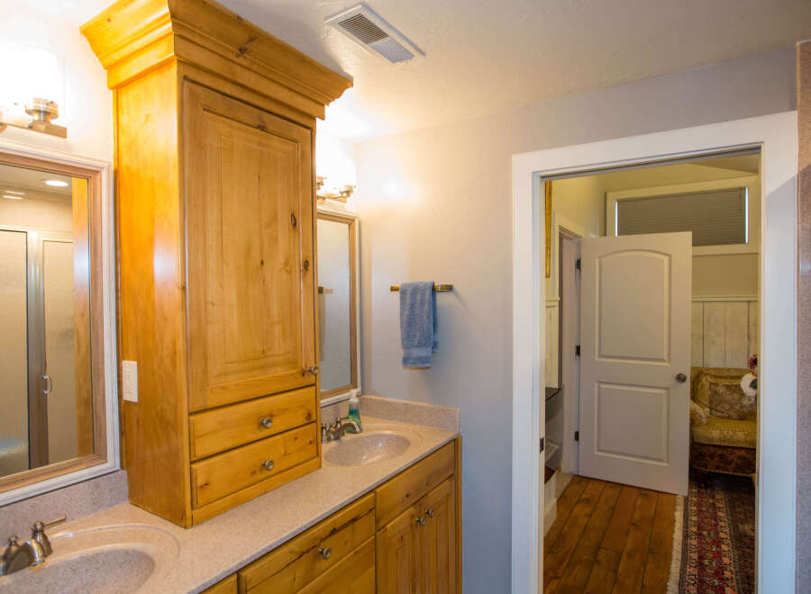 This beautiful bathroom features a custom wooden cabinet, providing ample storage space.