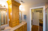 This beautiful bathroom features a custom wooden cabinet, providing ample storage space.