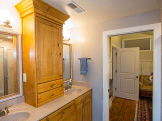 This beautiful bathroom features a custom wooden cabinet, providing ample storage space.