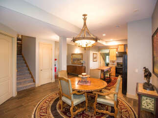 This stunning dining area features a beautiful round wooden table with elegant chairs, perfect for hosting gatherings.