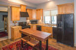 This stunning kitchen boasts beautiful wooden cabinetry and a sleek black appliance package.
