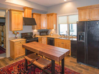 This stunning kitchen boasts beautiful wooden cabinetry and a sleek black appliance package.