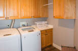 This laundry room features beautiful wooden cabinetry, providing ample storage space.