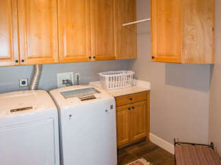 This laundry room features beautiful wooden cabinetry, providing ample storage space.